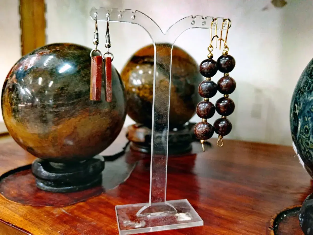 Boucles d'oreilles baguettes rouges et perles brunes sur support transparent