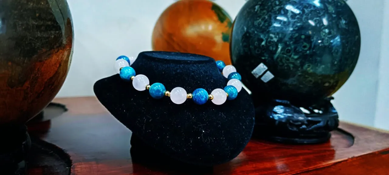 Bracelet de perles bleues et quartz rose sur support en velours noir