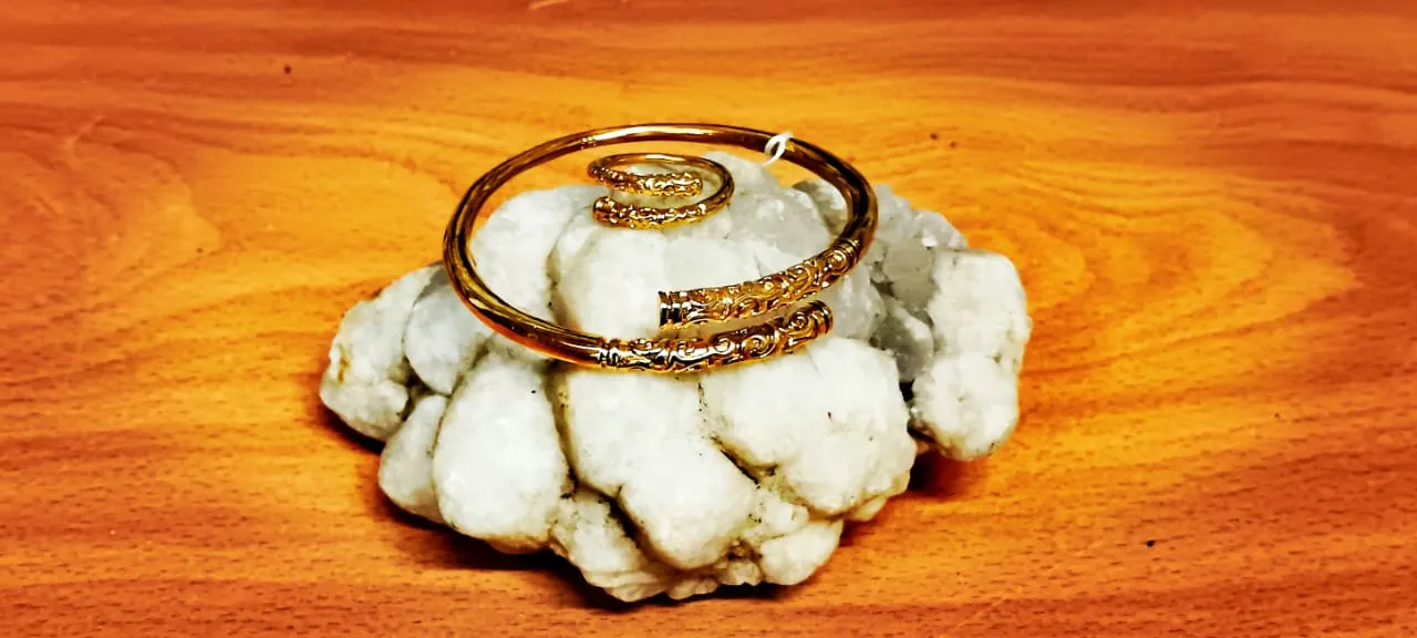 Bracelet spiralé doré, gravé d'une pierre blanche